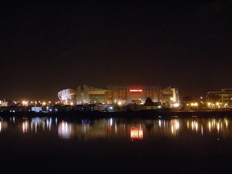 Estadio de fútbol iluminado durante la noche